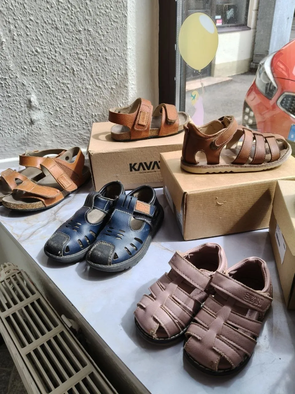 Flera par barnskor uppställda i butikens skyltfönster