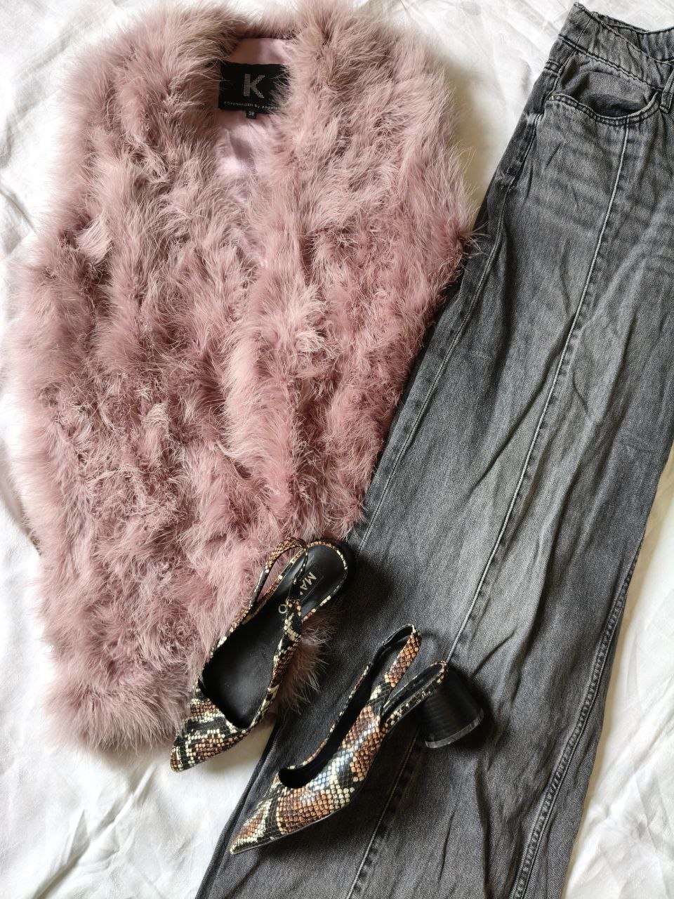 Rosa fluffig kofta, grå jeans och mönstrade pumps